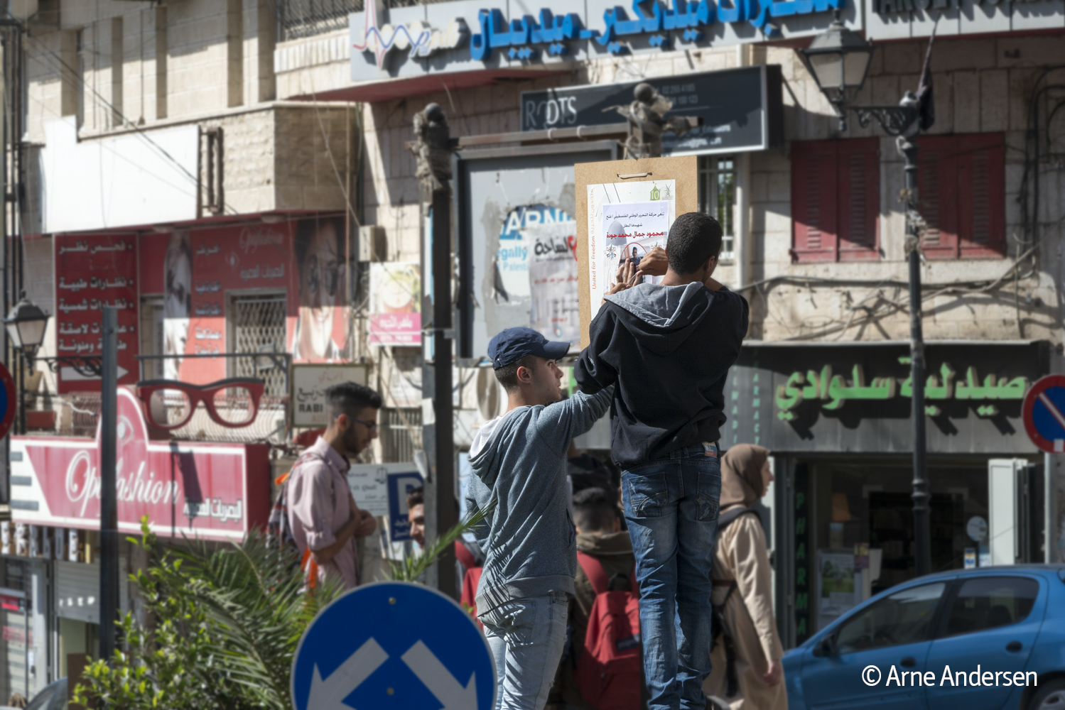 Junge Al Fatah-Kämpfer kleben Plakate